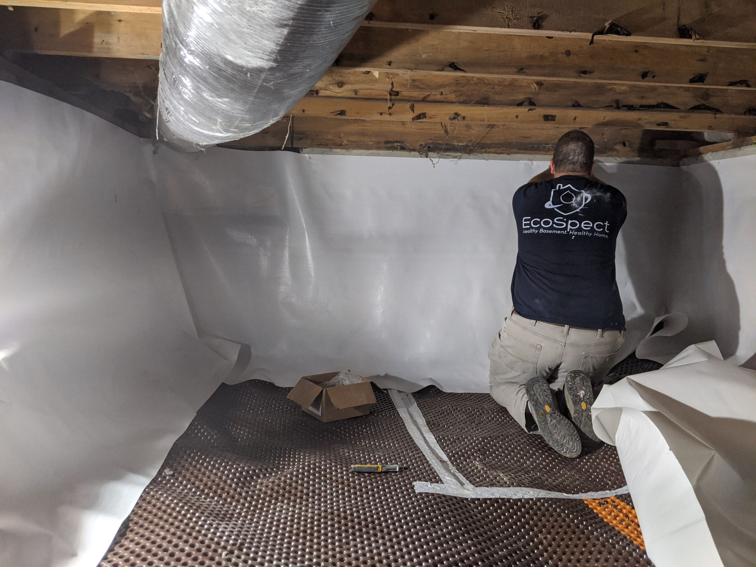 man working in a crawl space to get rid of mold